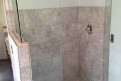 shower door with notched panel on knee wall with return